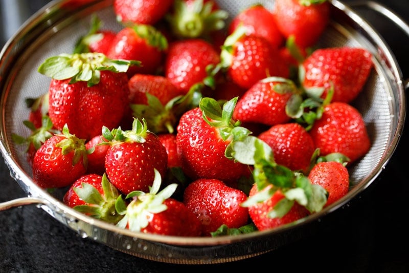 strawberries in a colander after rinsed with water and then dried naturally