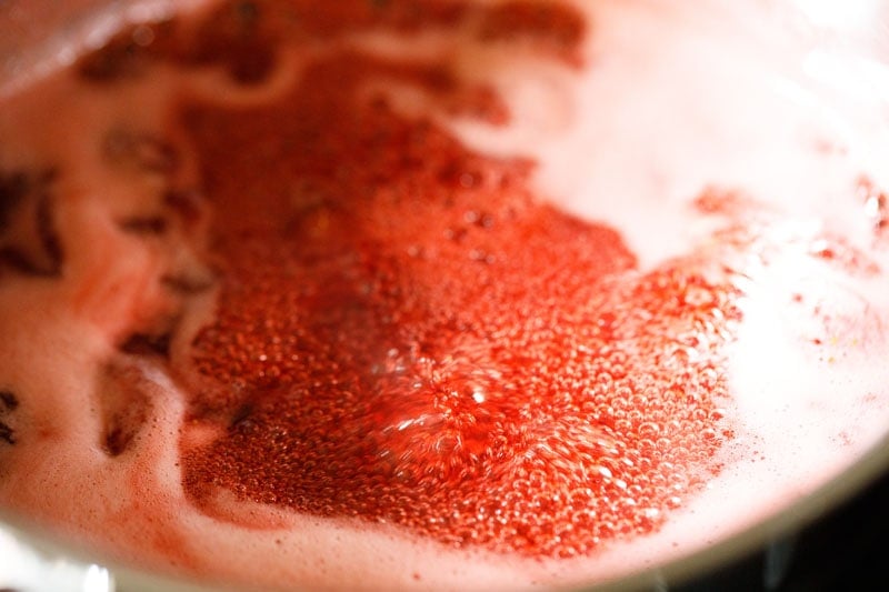 köchelnde Erdbeer-Marmeladen-Mischung - der Saft köchelt und schäumt