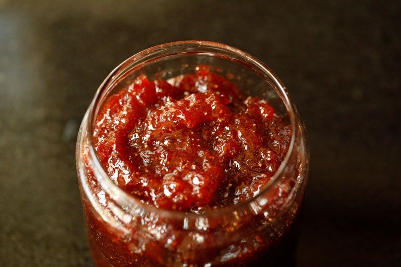 strawberry jam has been spooned into a glass jar.