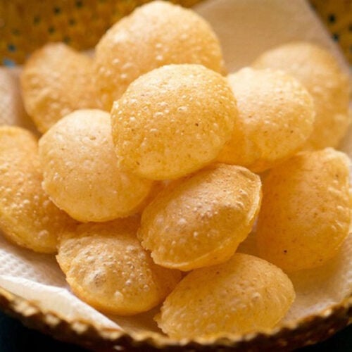 suji ke golgappe placed on paper towels on a bamboo basket