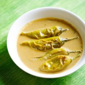 mirchi ka salan served in a white bowl on a green table.