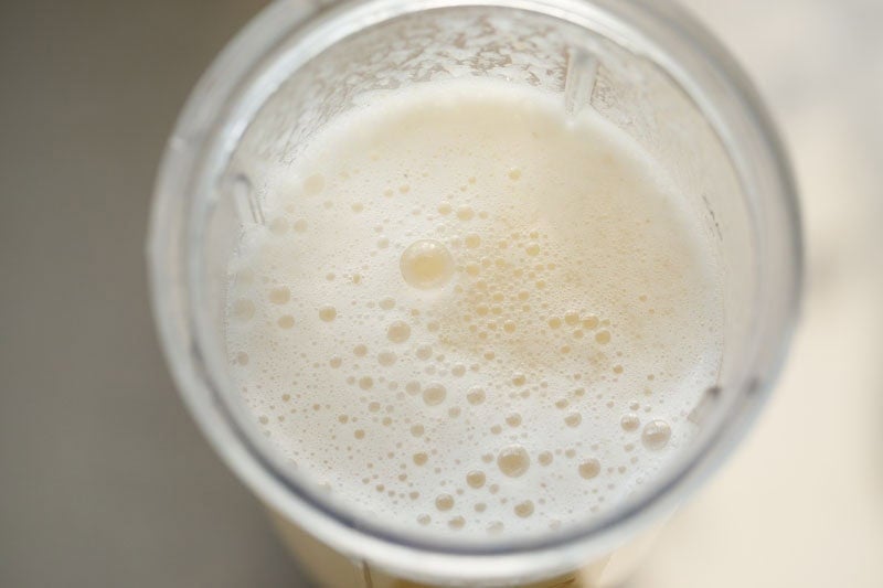 Water and sugar added to litchi pulp in blender.
