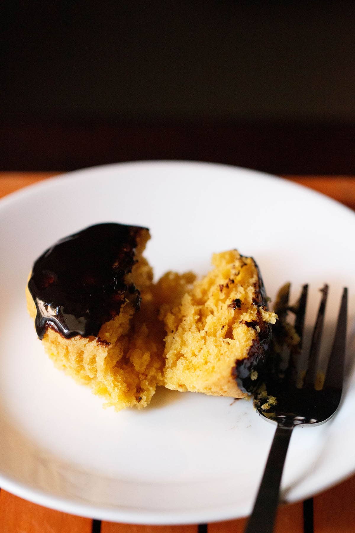 orange muffins halved on a plate with fork at side