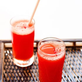 agua fresca served in glasses on a dark woven bamboo tray