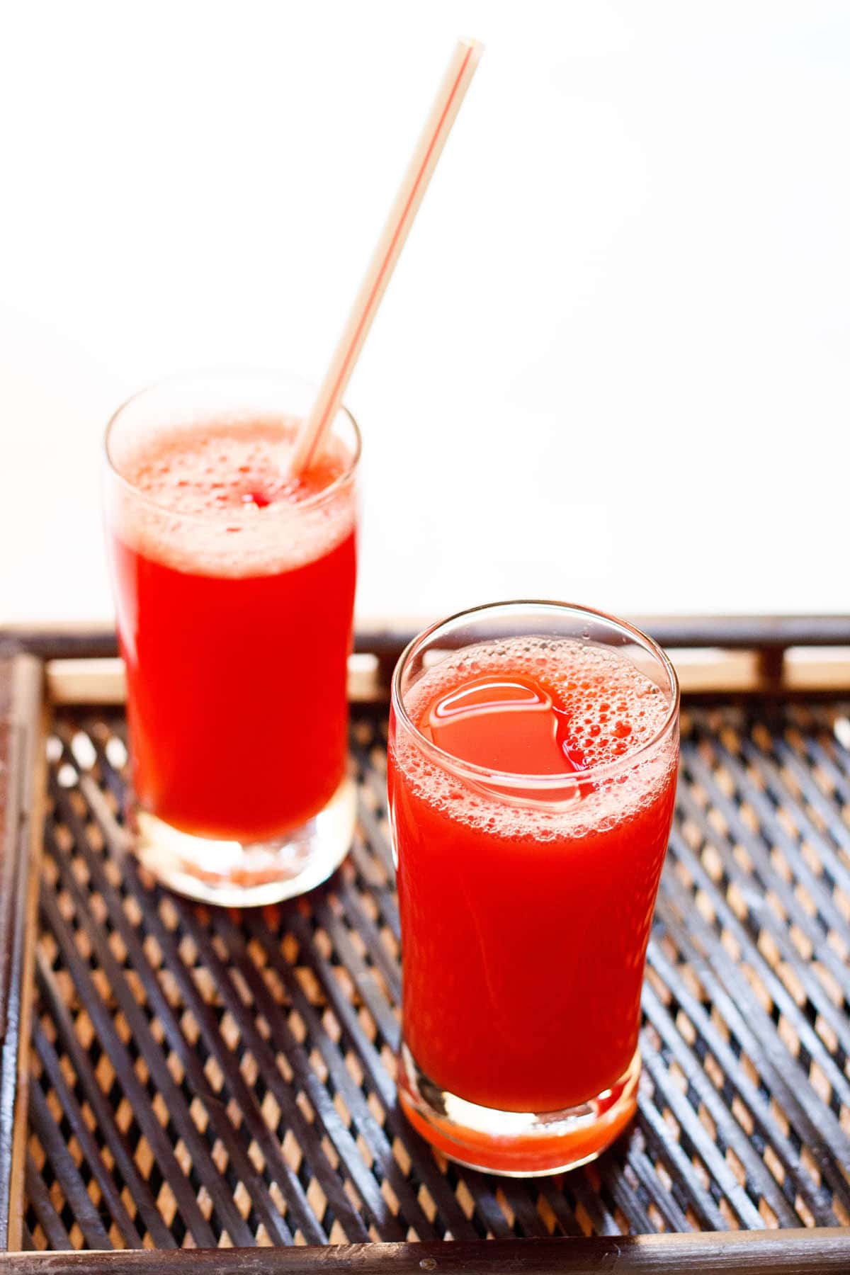 agua fresca served in glasses on a dark woven bamboo tray