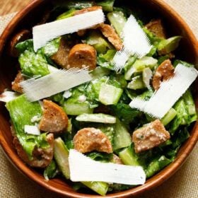 caesar salad with parmesan shavings in a wooden bowl.