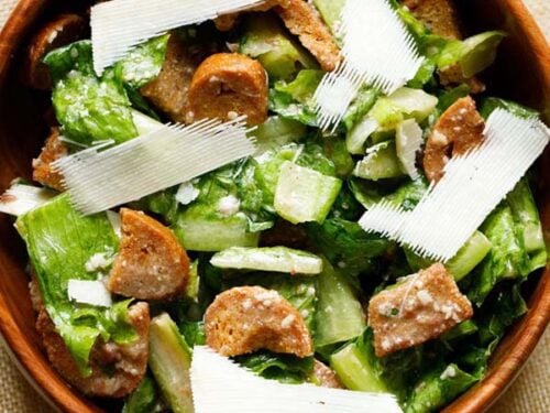 caesar salad with parmesan shavings in a wooden bowl.