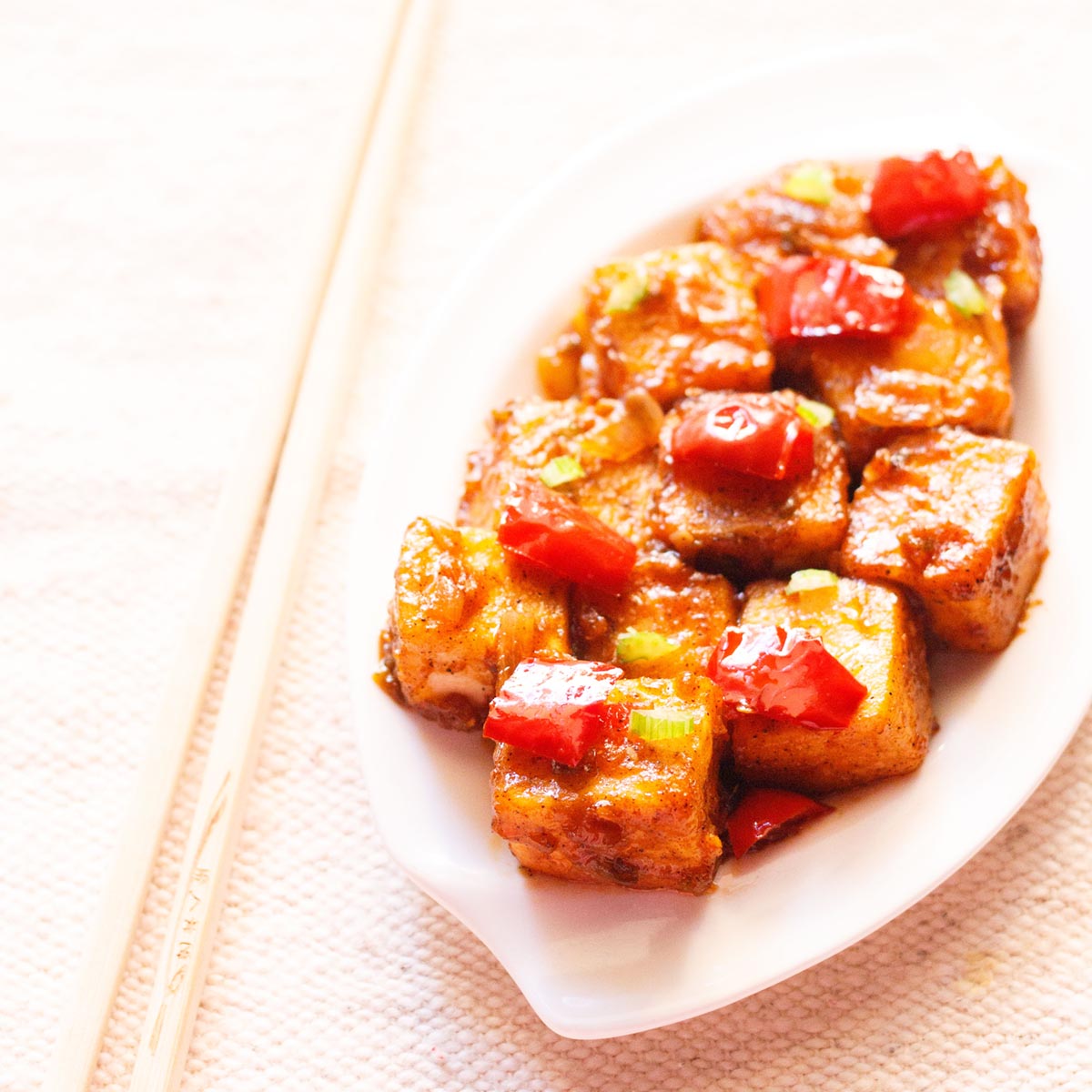 paneer manchurian on a white tray with chopsticks by the side.