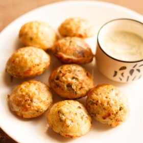 paniyaram on a plate with a side of coconut chutney.