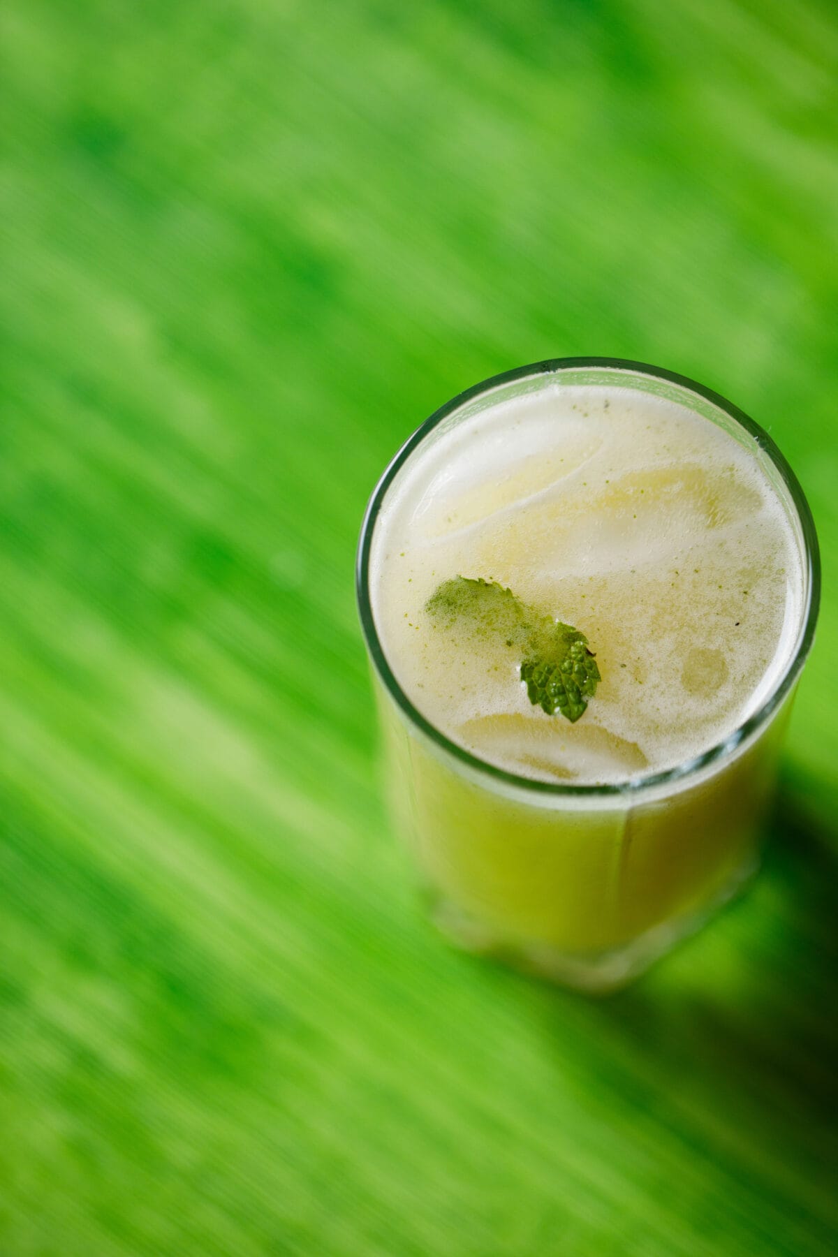 roasted aam panna in a glass on a green table.