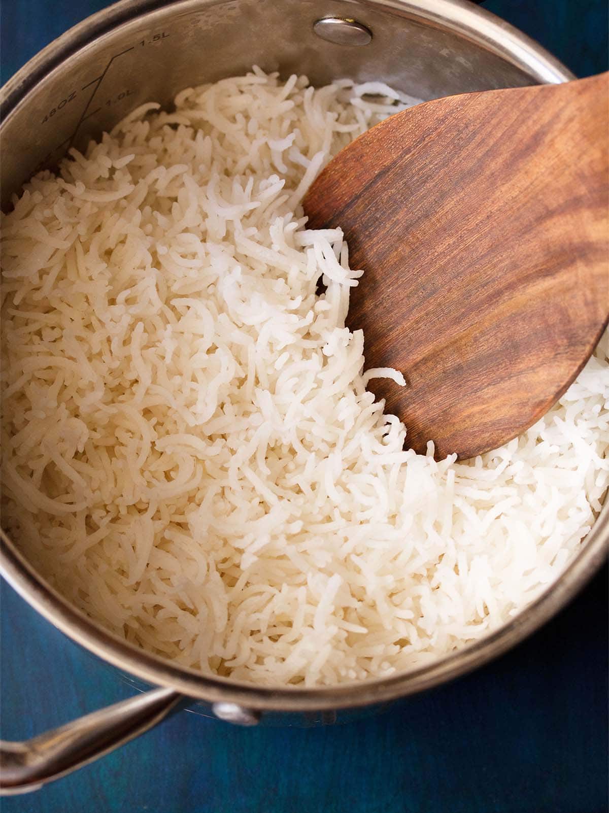cooked basmati rice in a pan with a wooden ladle. 