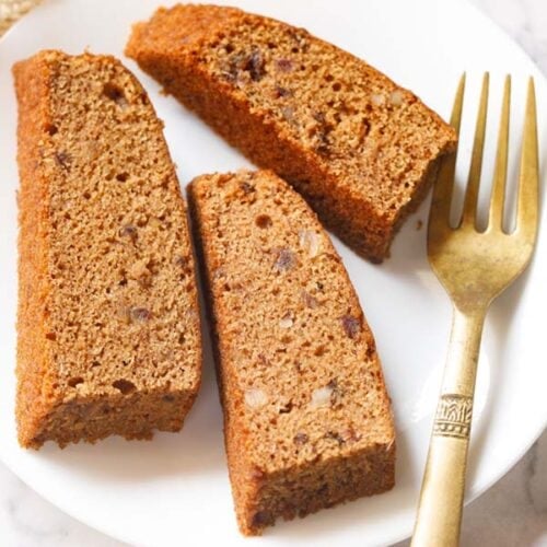 three date cake slices on white plate with golden fork by the side.