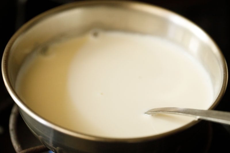 almond milk in a bowl on a lit stovetop.