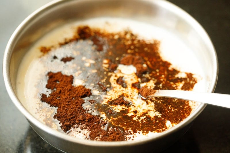 instant coffee sprinkled on almond milk in bowl.