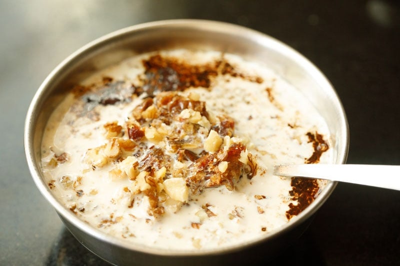 chopped dates and walnuts on top milk in bowl.