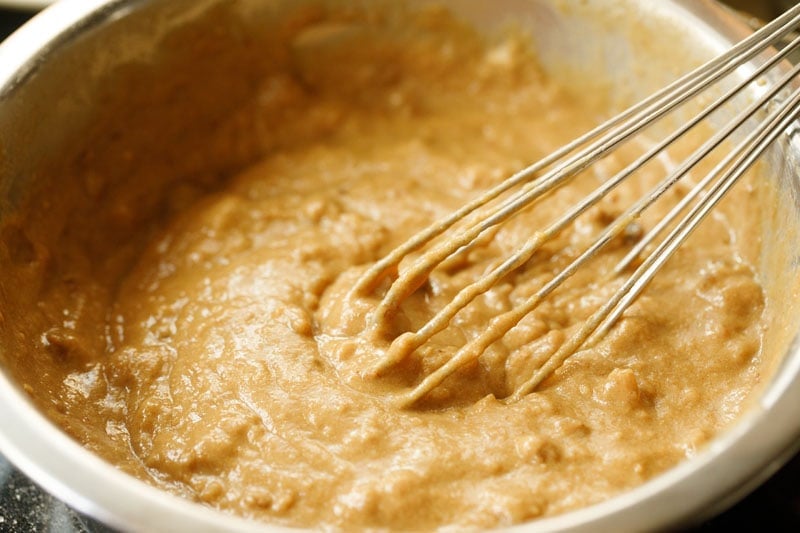 date walnut cake batter being made with a wired whisk.