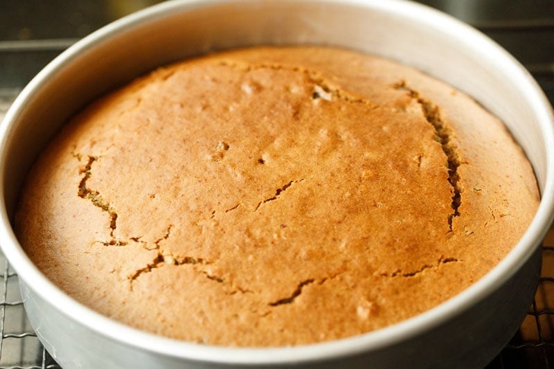 baked date cake inside pan on a wired tray.