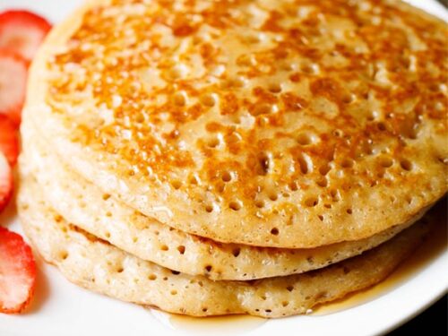 closeup shot of eggless pancakes on a white plate.