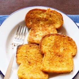 french toast without eggs on a white plate with fork by the side..