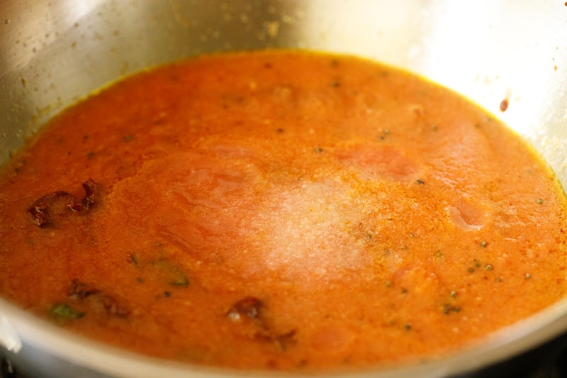 salt added to tomato puree in pan.