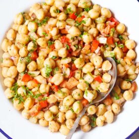 chickpea salad in a white plate with a spoon.