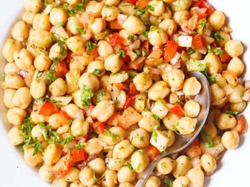 chickpea salad in a white plate with a spoon.
