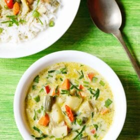 thai green curry in a white bowl with a plate of green curry and rice and a spoon at the top