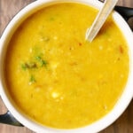 cooked masoor dal or red lentils in a bowl with spoon.