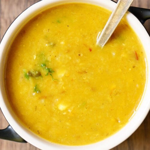 cooked masoor dal or red lentils in a bowl with spoon.
