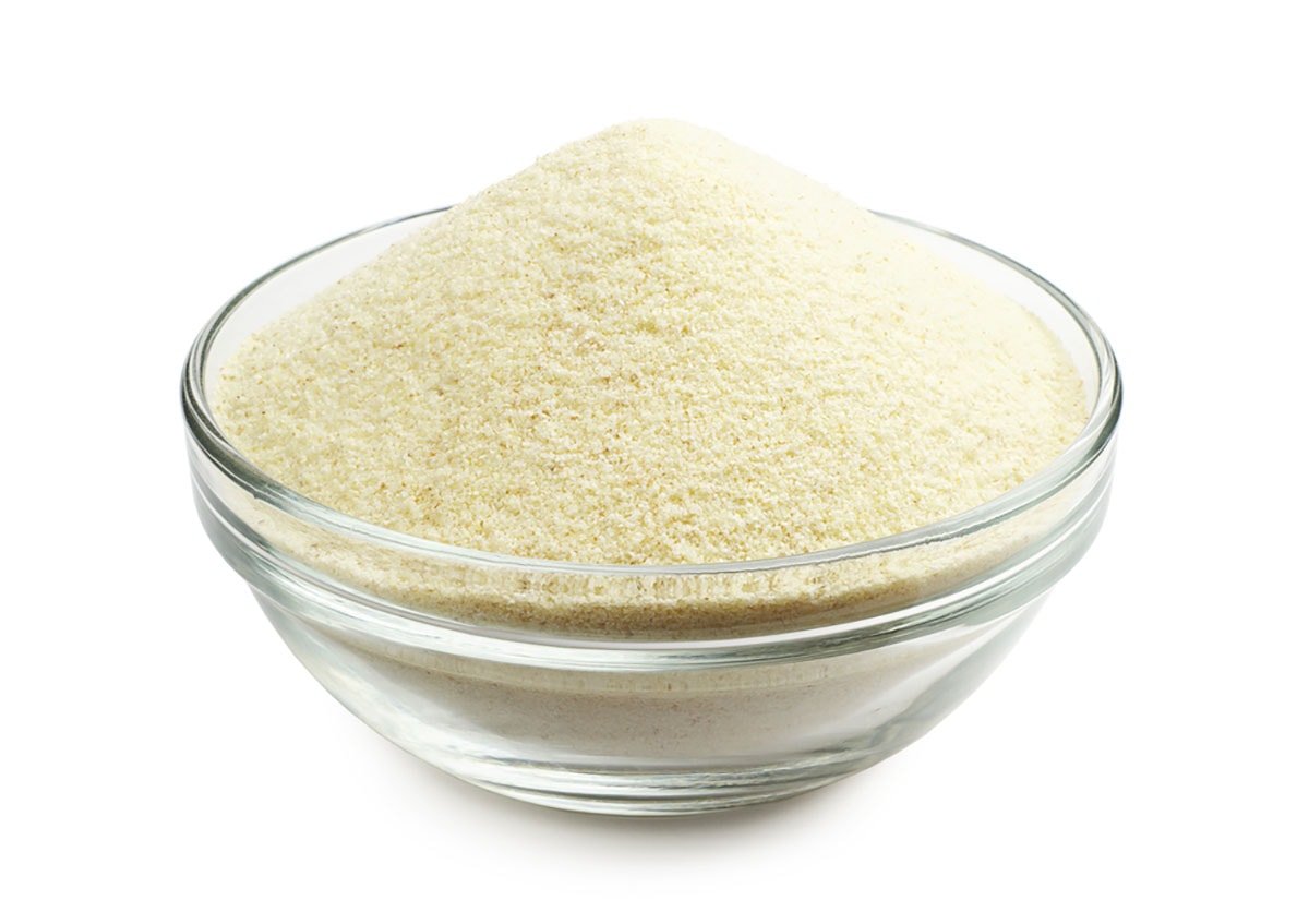mound of rava or suji or semolina in a glass bowl with a white background.