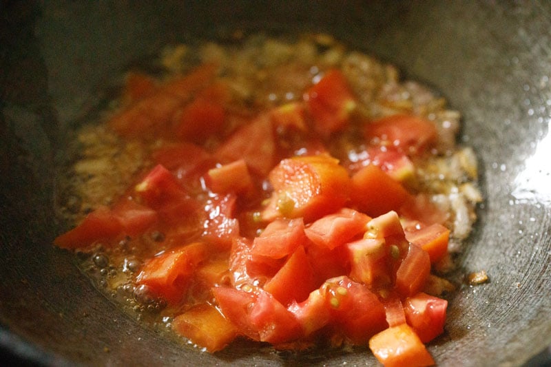 chopped tomatoes added to sautéed onions.