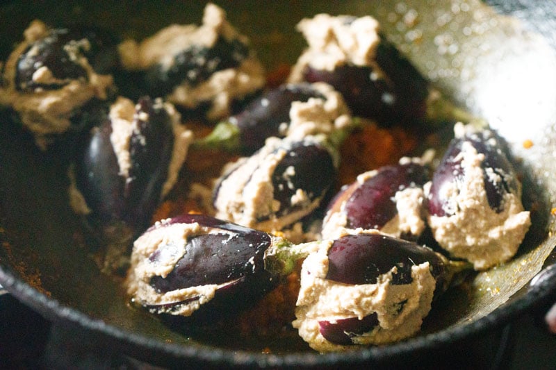 stuffed brinjals placed in pan on top of the masala.