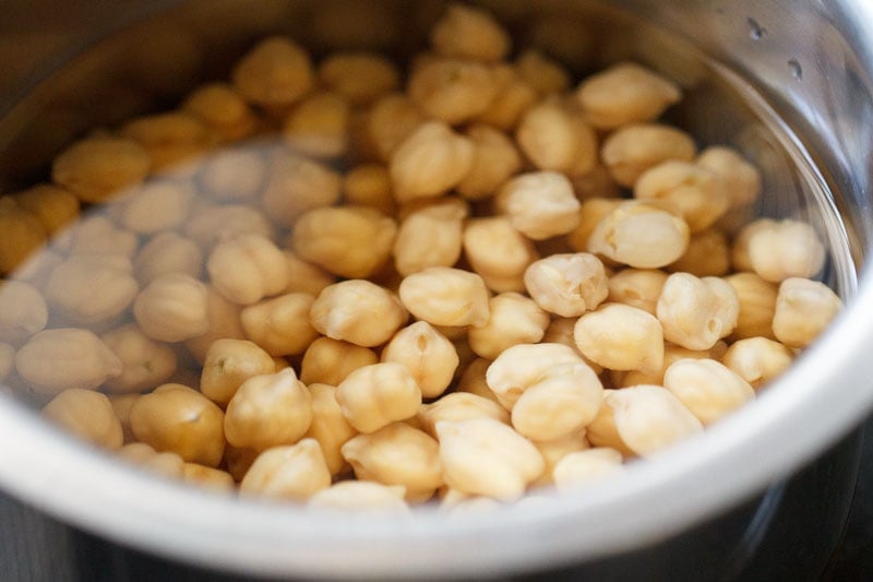 soaking dried white chickpeas in water for chickpea curry recipe. 