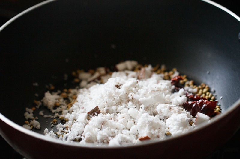 grated fresh coconut added to spices in the pan. 