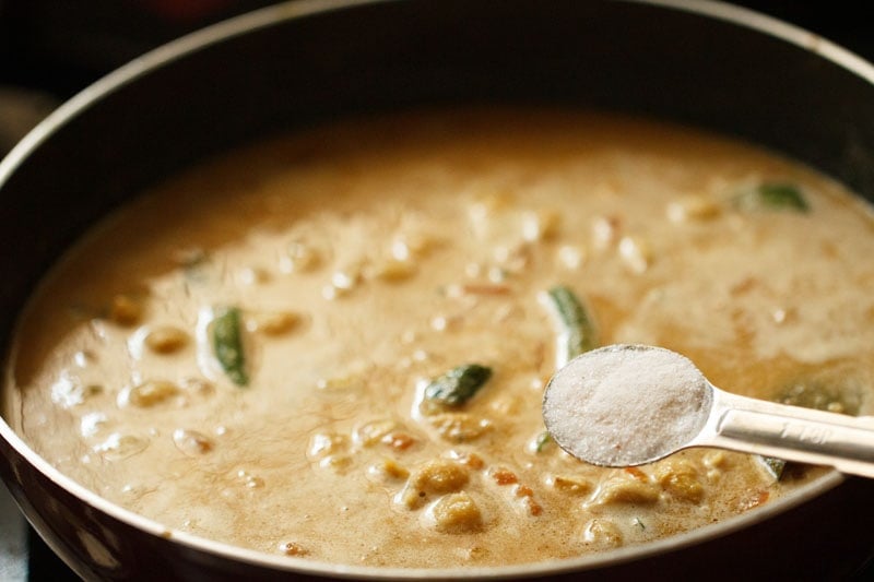 adding salt in the chickpea curry. 