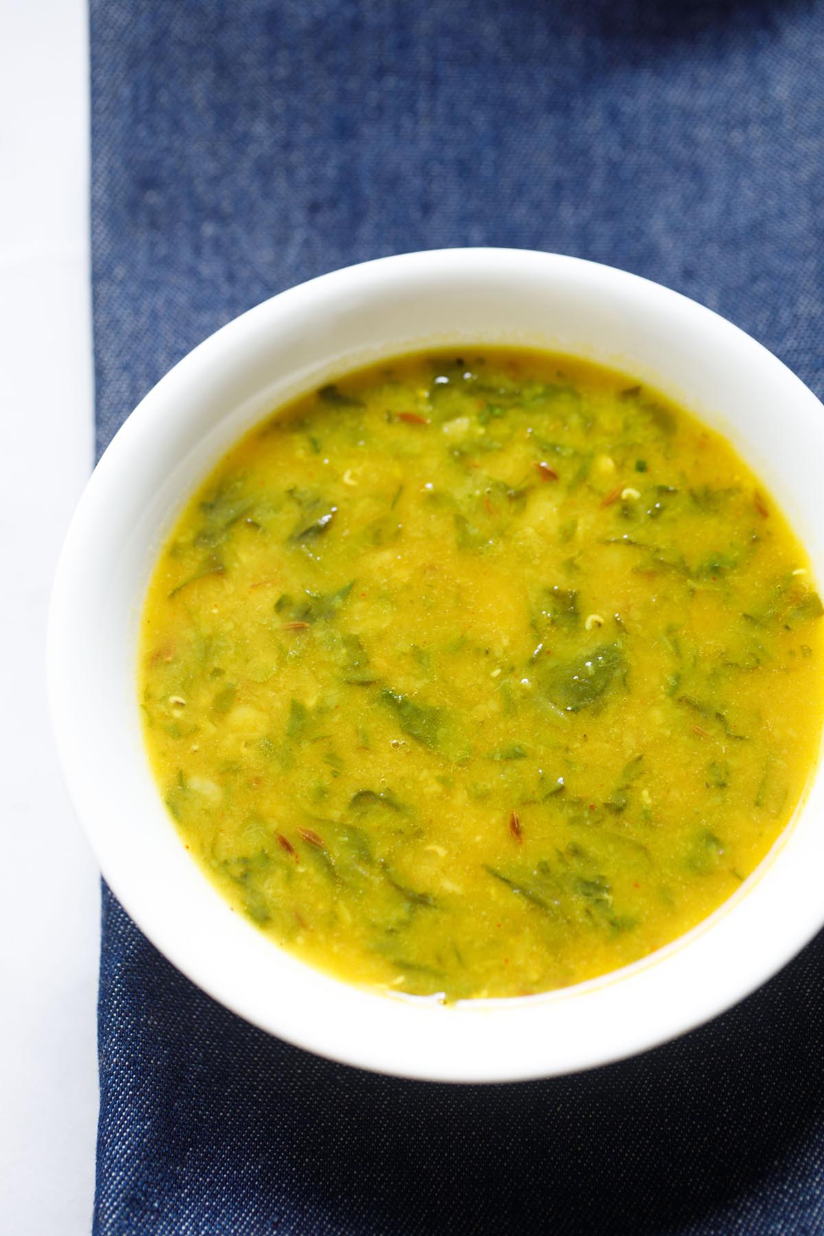 dal palak in a white bowl.