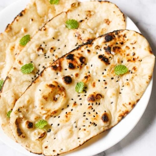 three garlic naan on a white plate.