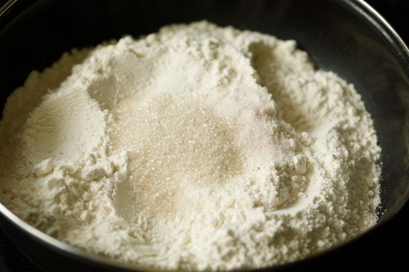 all purpose flour, sugar and salt added to a mixing bowl for making kerala paratha.