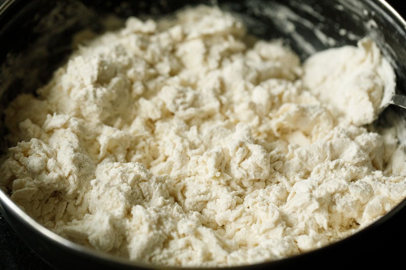 mixing flour with water using a spoon for making kerala paratha.