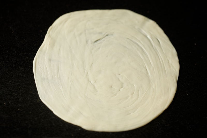 layered dough ball rolled into a disc for making malabar paratha.  