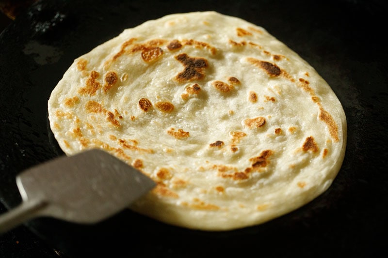 roasting malabar paratha with a spatula. 