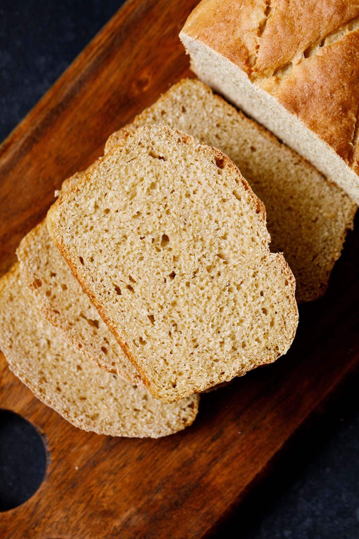 whole wheat bread slices on wooden board.