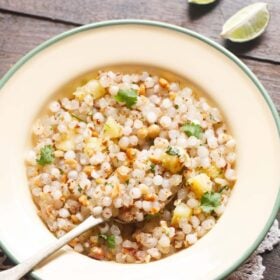 The sabudana khichdi is served on a green-rimmed cream plate with a brass spoon and text stopover.