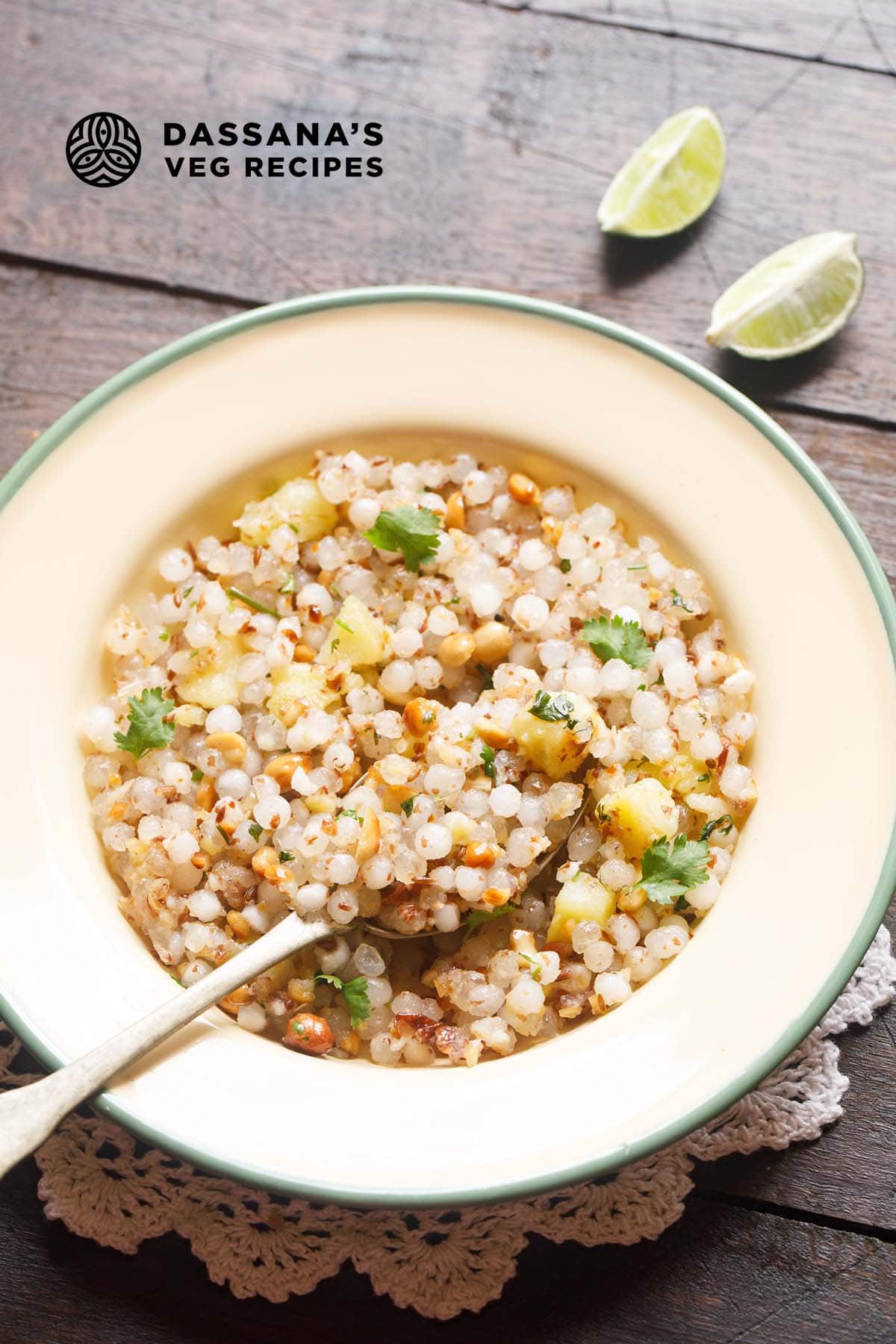 sabudana khichdi served in a green rimmed cream colored plate with a brass spoon and text layovers.