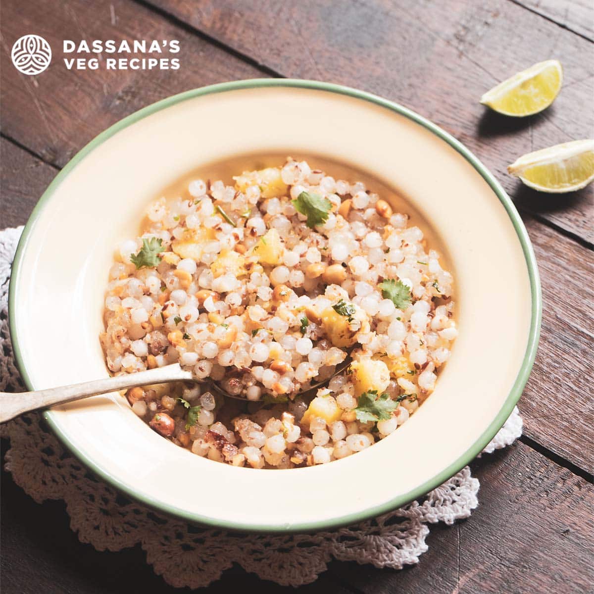 sabudana khichdi served in a green rimmed cream colored plate with a brass spoon and text layovers.