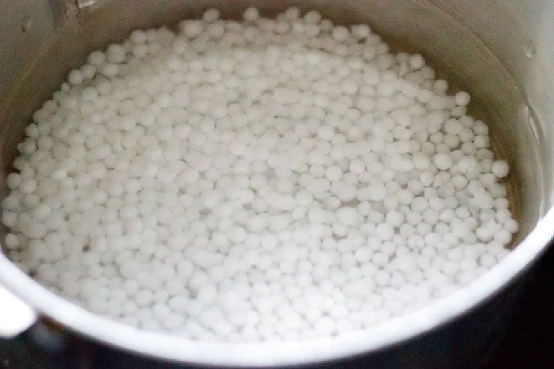 Rinsed sabudana added to water in a saucepan.