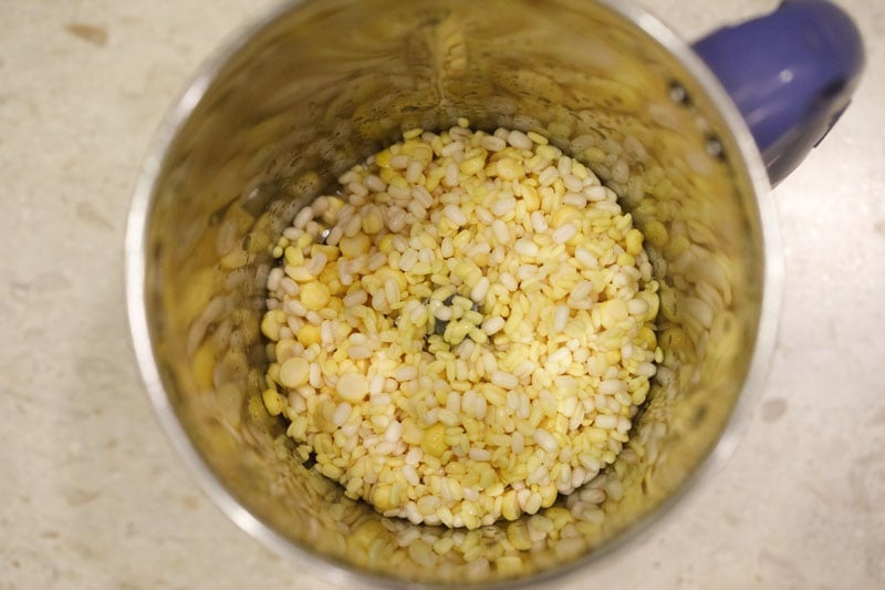 drained lentils added to a blender for making batter for paddu. 
