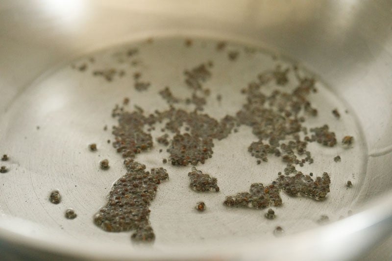 mustard seeds spluttering in hot oil for making tempering mixture for paddu. 