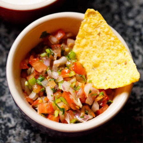 pico de gallo or salsa fresca in a bowl with a nacho chip.