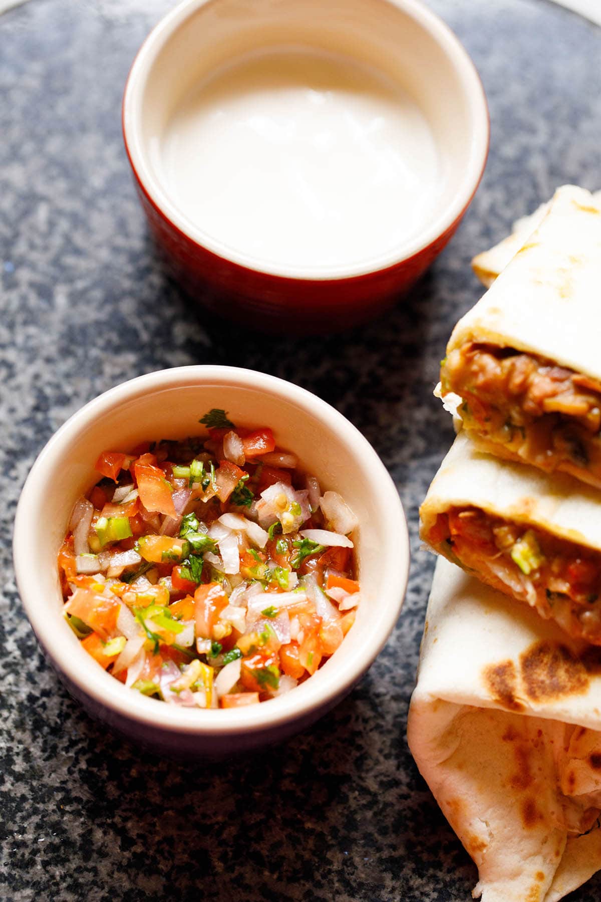 pico de gallo in a bowl with burrito wraps placed next to it.